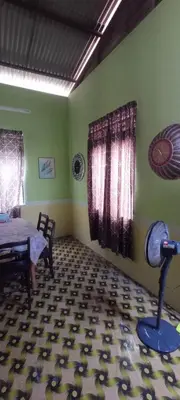 a dining room with a table and a floor at Kurnia Homestay in Slim River