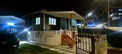 a small house with a gate at night at Kurnia Homestay in Slim River