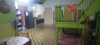 a living room with a green staircase and a kitchen at Kurnia Homestay in Slim River
