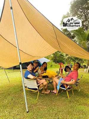 a group of people sitting in chairs under a tent at Lipis Riverfront Resort in Kuala Lipis