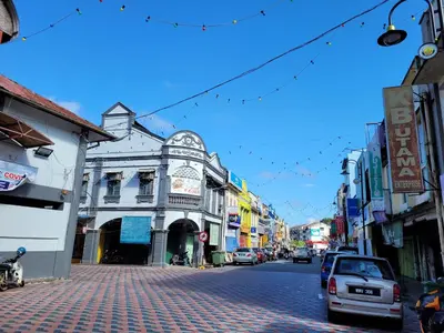a city street with cars parked on a brick road at Lipis Riverfront Resort in Kuala Lipis
