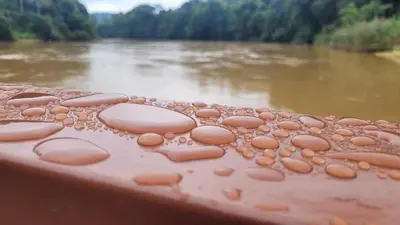 a table with water droplets on it next to a river at Lipis Riverfront Resort in Kuala Lipis