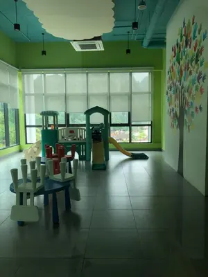 a room with a playground with chairs and a slide at Onsen Oasis Premium Suites in Tambun
