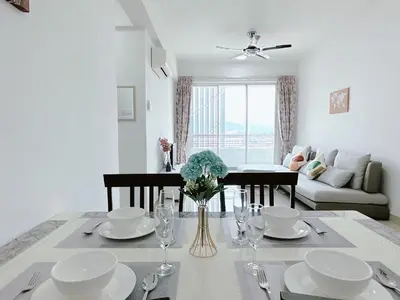 a living room with a dining room table with plates and glasses at Ipoh Town - Majestic Cozy Deluxe Homestay in Ipoh