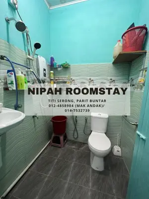 a bathroom with a white toilet and a sink at NIPAH ROOMSTAY PARIT BUNTAR in Parit Buntar
