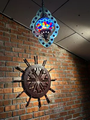 a clock on the side of a brick wall with a light fixture at Maxwell inn in Taiping
