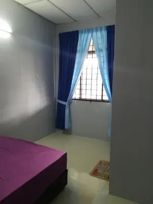 a bedroom with a purple bed and a window at Homestay siti in Padang Serai