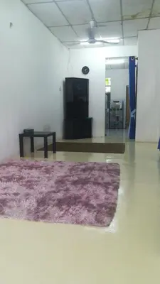 a living room with a purple rug on the floor at Homestay siti in Padang Serai