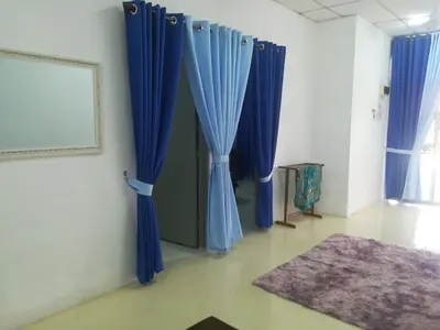 a room with blue curtains and a rug on the floor at Homestay siti in Padang Serai