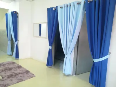 a room with blue curtains and a carpet at Homestay siti in Padang Serai