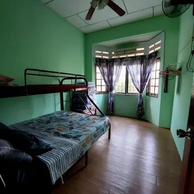 a bedroom with a bed in a room with green walls at Adam Homestay in Ipoh