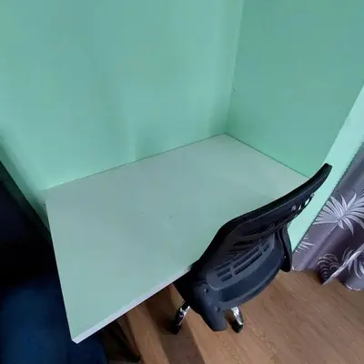 a black bird sitting under a white desk at Adam Homestay in Ipoh