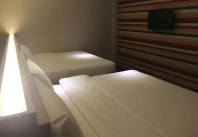 two beds in a small room with two beds sidx sidx sidx at Merge Summit by Secoms in Teluk Intan