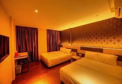 a hotel room with two beds and a couch at Merge Summit by Secoms in Teluk Intan