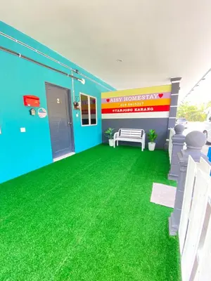 a room with green grass on the floor at AISY HOMESTAY - Rumah 2 atau 3 in Kampong Tanjong Karang