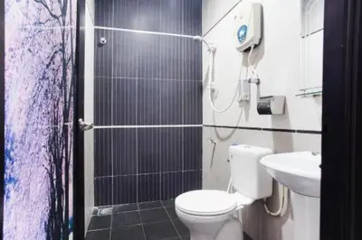 a bathroom with a shower and a toilet and a sink at Sejati Hotel in Sitiawan