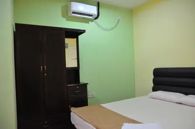 a bedroom with a bed and a tv on the wall at Deena Hotel Bajet in Gua Musang