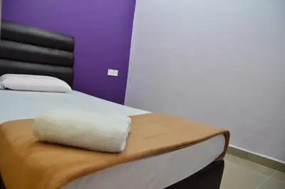 a bed with a white pillow sitting on top of it at Deena Hotel Bajet in Gua Musang