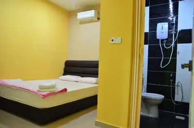 a small room with a bed and a toilet at Deena Hotel Bajet in Gua Musang