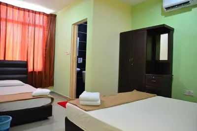 a bedroom with two beds and a cabinet and a window at Deena Hotel Bajet in Gua Musang