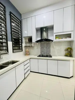 a white kitchen with white cabinets and a sink at SRS WIN Homestay in Sungai Petani