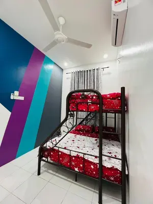 a bunk bed with red beds in a room with a ceiling at SRS WIN Homestay in Sungai Petani