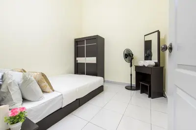 a bedroom with a bed and a desk with a fan at Zai Ham Homestay in Pusing