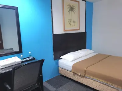 a bedroom with a bed and a desk with a mirror at Shangg INN in Ipoh