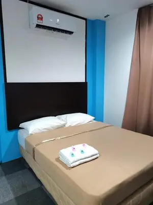 a bed with a white towel on top of it at Shangg INN in Ipoh