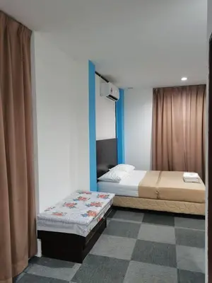 a bedroom with two beds and a blue wall at Shangg INN in Ipoh