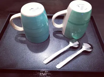 two cups and spoons sitting on a tray at Shangg INN in Ipoh