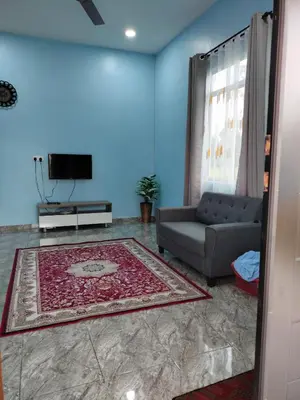 a living room with a couch and a tv at Rizki Homestay Nibong Tebal in Nibung Tebal