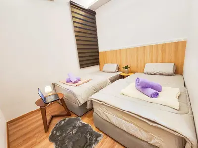 a room with two beds with purple pillows on them at IPOH The COVE at Ipoh Garden East 7 PAX Cozy Fully Air-Con in Ipoh
