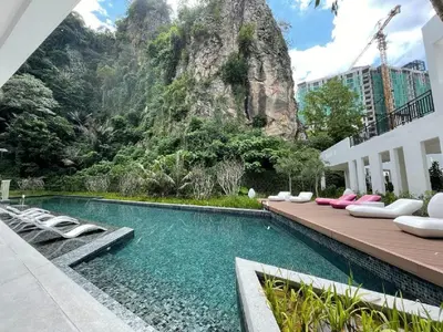a swimming pool with lounge chairs and a mountain at IPOH The COVE at Ipoh Garden East 7 PAX Cozy Fully Air-Con in Ipoh