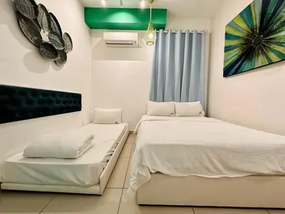 a bedroom with two beds and a painting on the wall at The Majestic-Loft De Tel in Ipoh
