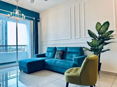 a living room with a blue couch and a chair at The Majestic-Loft De Tel in Ipoh