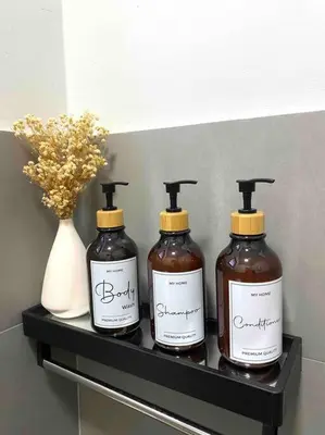 three bottles of honey and a vase on a shelf at Stylish Cozy House Near Ipoh Lost World Tambun in Kampong Batu Lapan