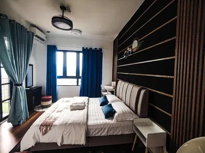 a bedroom with a large bed and blue curtains at Studio suite nearby Lost World of Tambun in Tambun