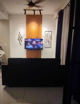 a living room with a couch and a flat screen tv at Studio suite nearby Lost World of Tambun in Tambun