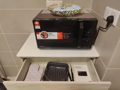 a microwave sitting on top of a shelf in a kitchen at Studio suite nearby Lost World of Tambun in Tambun
