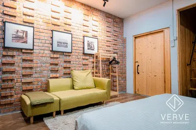 a bedroom with a couch and a brick wall at Ipoh 188 Private Pool Mansion by Verve 30 pax EECH119 in Ipoh