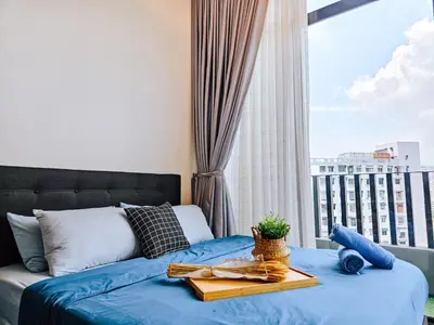 a bedroom with a blue bed and a window at Beacon Executive Suite by NGN - Georgetown Penang in George Town