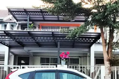 a car parked in front of a house with a flower pot at Homestay Kampar Putra in Kampar