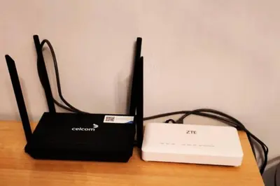 a modem and a laptop sitting on a table at Homestay Kampar Putra in Kampar
