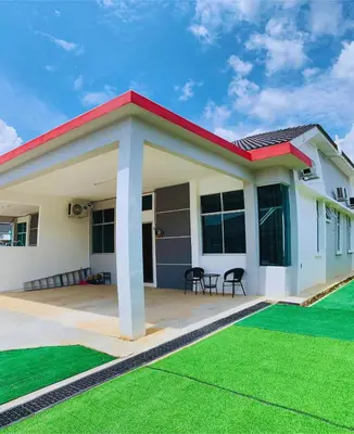 a house with a green lawn in front of it at D' Splash Garden Homestay in Baling