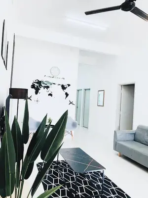 a living room with a blue couch and a plant at D' Splash Garden Homestay in Baling