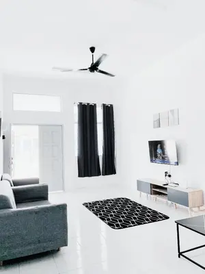 a white living room with a couch and a tv at D' Splash Garden Homestay in Baling