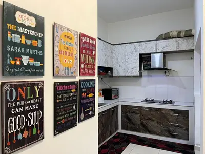 a kitchen with posters on the wall and a counter at idaman hill homestay in Ipoh