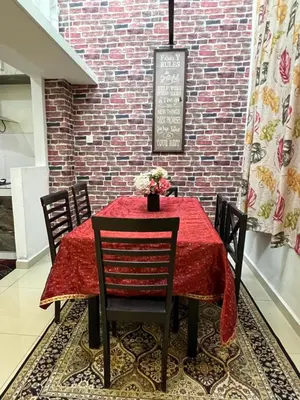 a dining room with a red table with chairs and a brick wall at idaman hill homestay in Ipoh