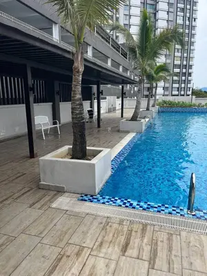 a swimming pool with two palm trees and a building at idaman hill homestay in Ipoh